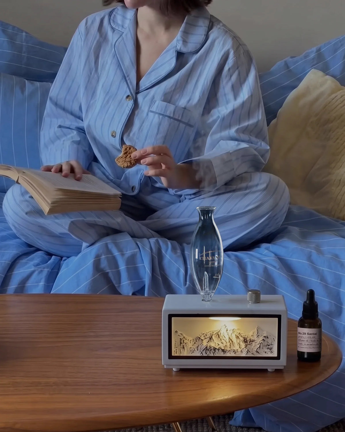 Chavanc Alpine waterless essential oil diffuser in pure white wood base with illuminated snow mountain landscape in cozy bedroom evening routine