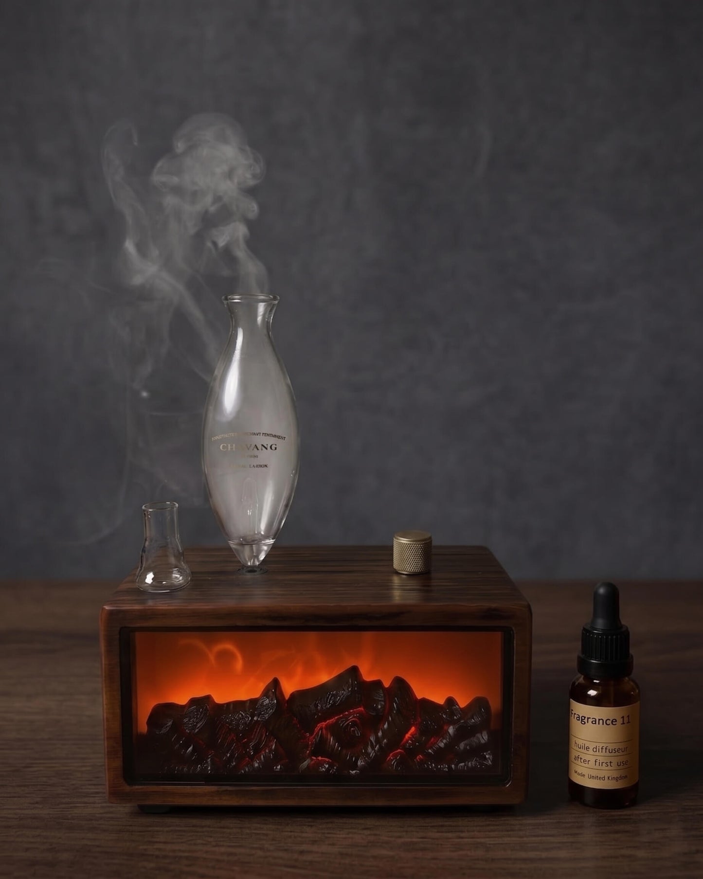 Decorative setup with a smoking flask, wooden box with glowing embers, and a bottle on a dark background