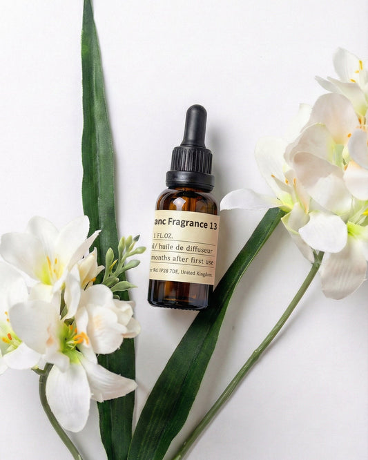Chavanc Aroma NO.13 Pear Freesia Whisper essential oil bottle displayed with elegant white freesia flowers and green leaves on a clean white background.