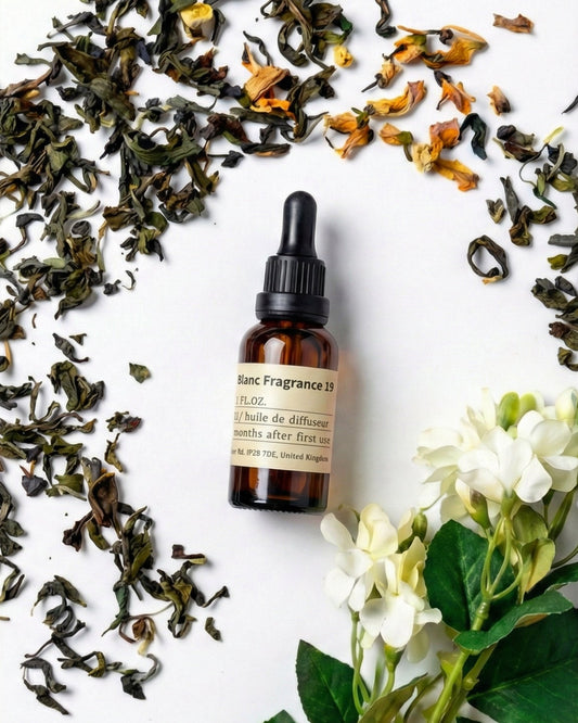 chavanc aroma NO.19 All-Season Zen Tea essential oil bottle surrounded by loose green tea leaves and white jasmine flowers, evoking a serene tea ritual.
