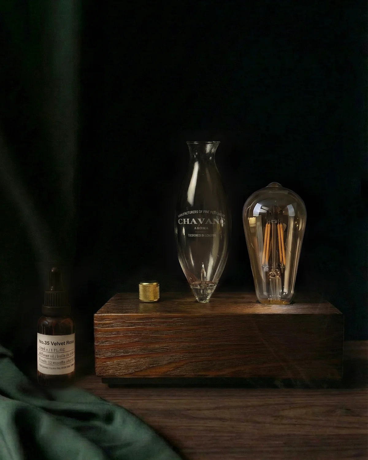 Vintage-style light bulb and bottle on a wooden base with smoke effect