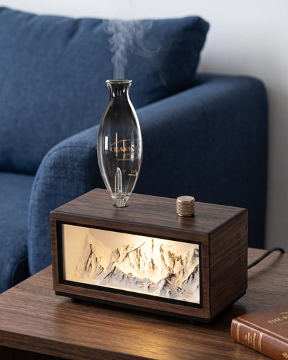 Chavanc Alpine waterless essential oil diffuser emitting dry mist with illuminated snow mountain relief in dark walnut wood base