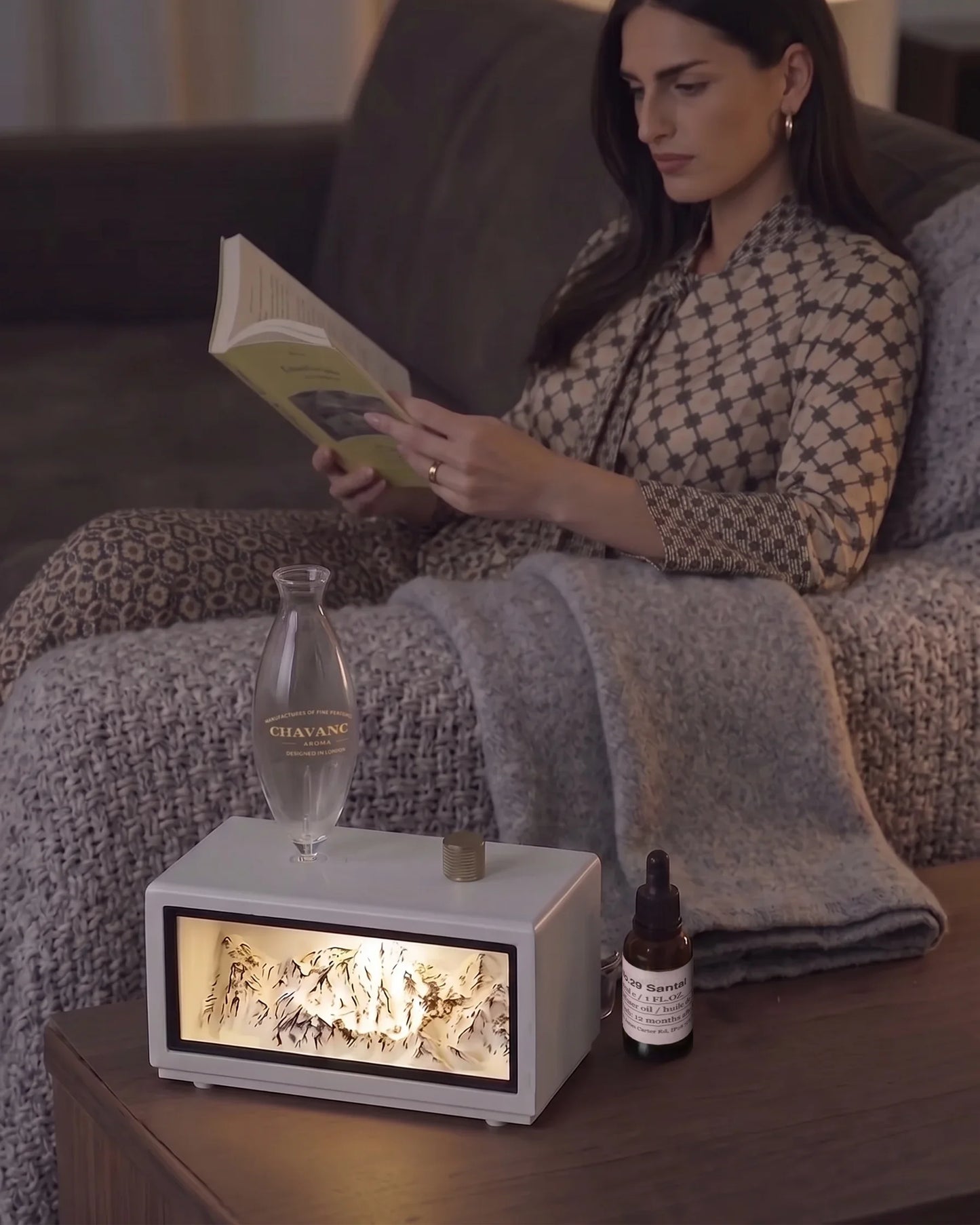 Chavanc Alpine waterless essential oil diffuser in pure white wood base with illuminated snow mountain landscape in cozy living room reading atmosphere