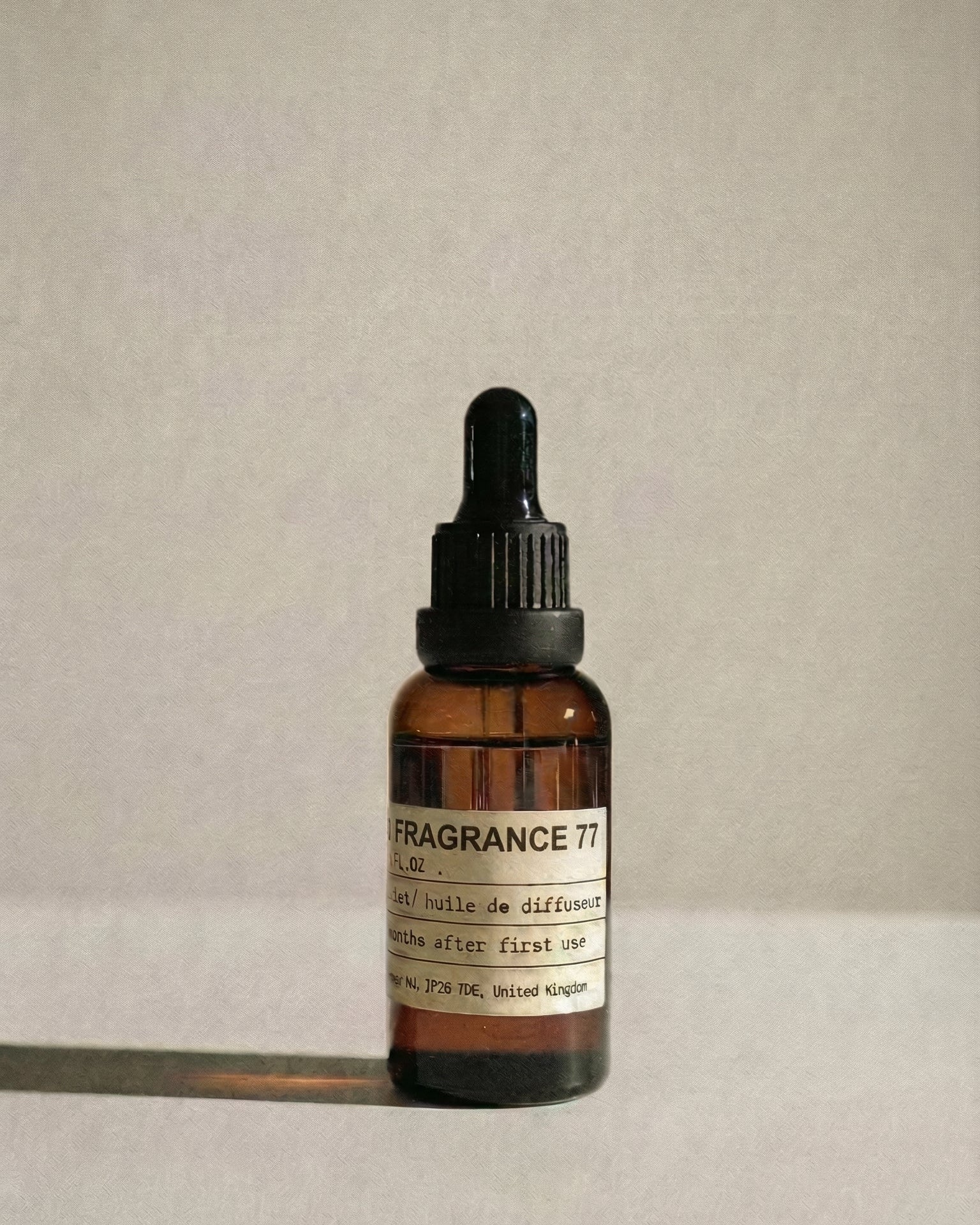 Amber glass bottle of Chavanc_Aroma  77 Pineapple Bliss Noir essential oil with vintage apothecary label.