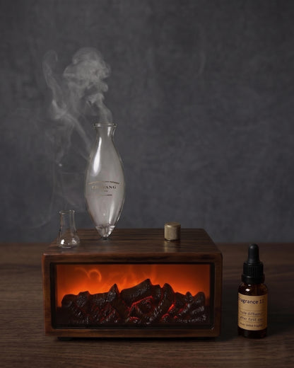 Decorative setup with a smoking flask, wooden box with glowing embers, and a bottle on a dark background