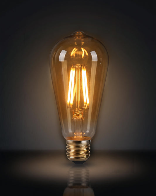 A classic ST64 clear glass LED replacement bulb for a Chavanc
aromatherapy diffuser, featuring four vertical warm-light filaments. The vintage Edison-style bulb is displayed on decorative, stacked cream ceramic plates with intricate scalloped edges, perfect for maintaining a timeless and elegant look for high-end home fragrance setups.