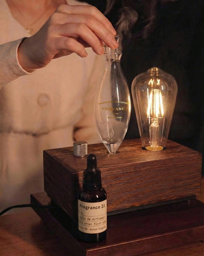 Person using a glass bottle with a wooden base and a lit light bulb.