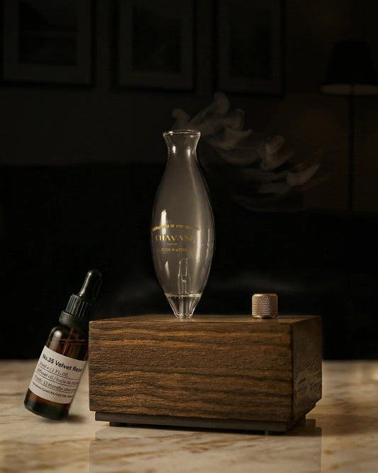 Wooden diffuser with glass bottle and dropper on a dark background
