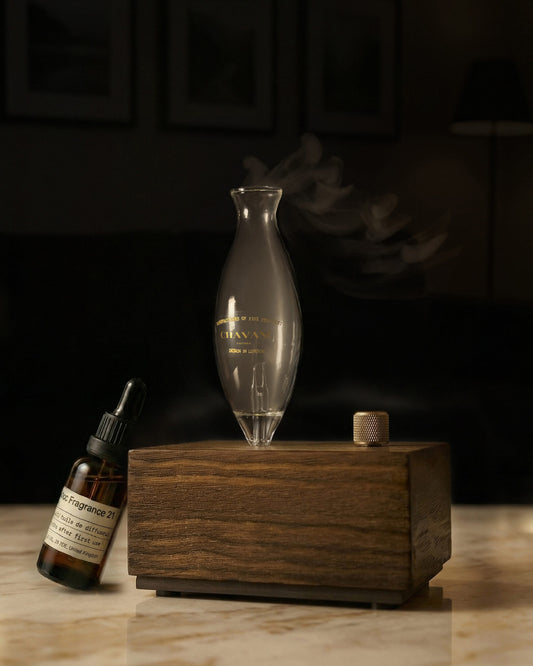 Wooden diffuser with glass bottle and dropper on a dark background