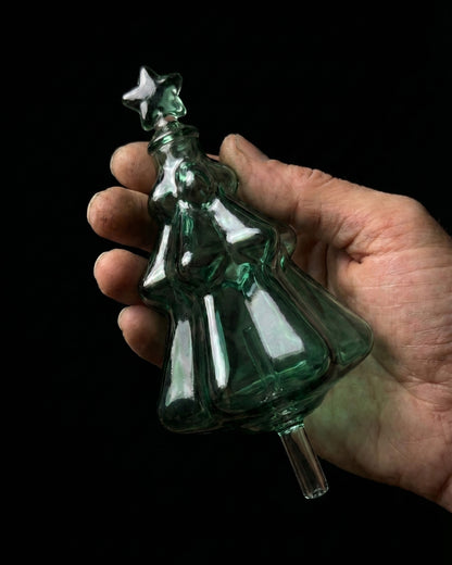 A beautiful emerald green tinted glass nebulizing flask in the shape of a Christmas tree, designed as a replacement accessory for Chavanc essential oil diffusers. 